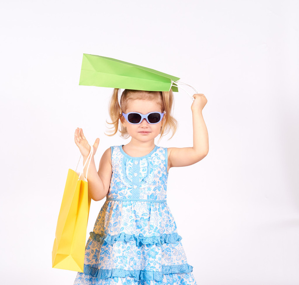 Shopping child. little girl holding shopping bags - Fotó, kép
