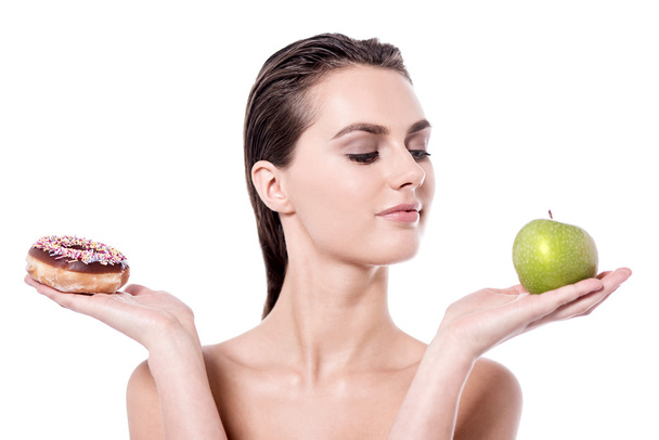 woman holding doughnut and apple - Photo, image