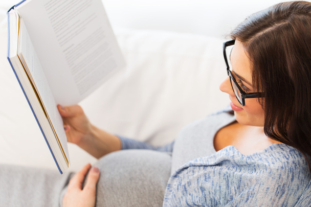 close up of pregnant woman reading book at home - Foto, Bild