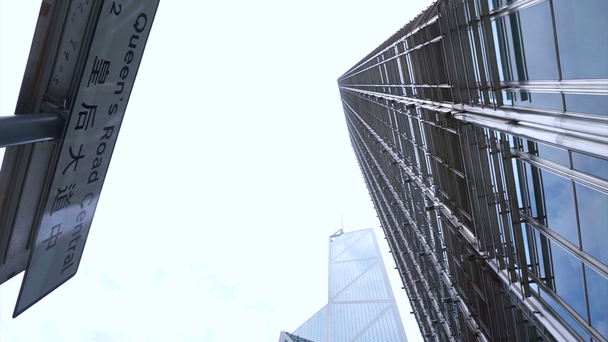 Az alsó nézet háttérégbolt felhőkarcolók. Üzleti negyed absztrakt pénzügyi épületek Queen's road, Central, Hong Kong - Felvétel, videó