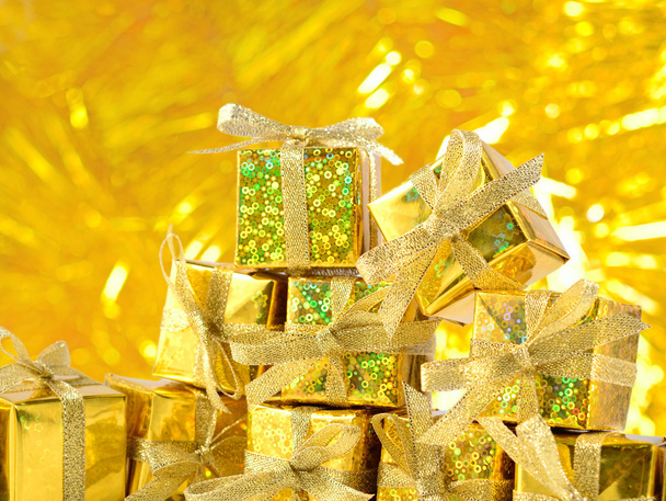 Regalos de oro sobre un fondo bokeh dorado
  - Foto, Imagen
