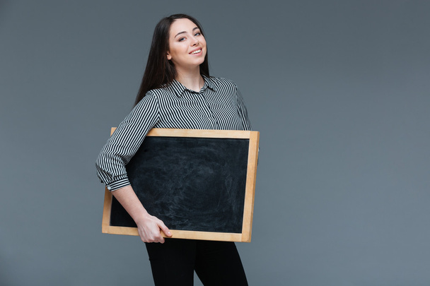 Happy woman holding blank black board  - Foto, immagini