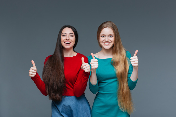 Two happy girls showing thumbs up - Fotó, kép