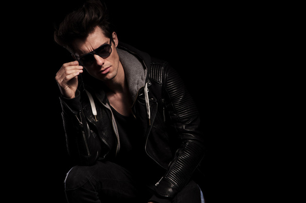 young fashion model in leather jacket taking off his sunglasses - Φωτογραφία, εικόνα