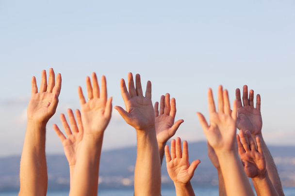 Onherkenbaar mensen trekken handen in de lucht - Foto, afbeelding