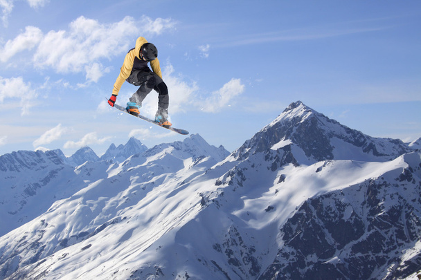 スノーボードライダー山の上でジャンプします。極端なスノーボードフリーライドスポーツ. - 写真・画像