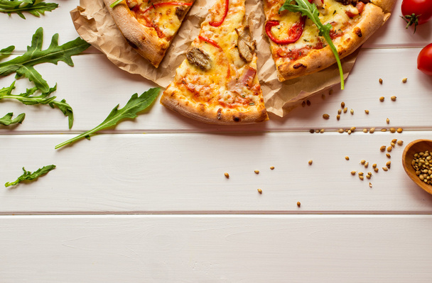 Üstten Görünüm taze pişmiş pizza dilimi ahşap masaya servis - Fotoğraf, Görsel