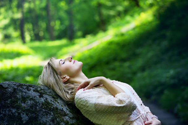 Девушка отдыхает в лесу на скале
 - Фото, изображение