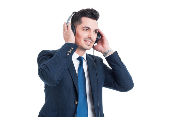 Succesvolle knappe zakenman luisteren en genieten van muziek op  - Foto, afbeelding
