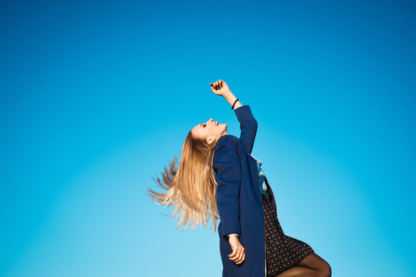 young beautiful girl on a background of blue sky - Fotoğraf, Görsel