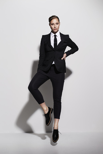 Posing businesswoman in cool black suit - Fotó, kép