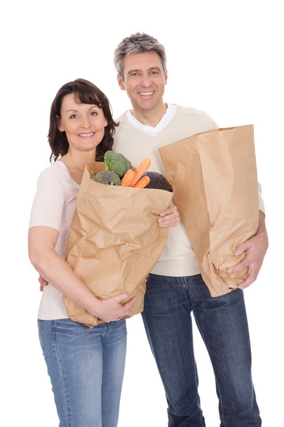 Happy couple with grocery shopping bags - 写真・画像