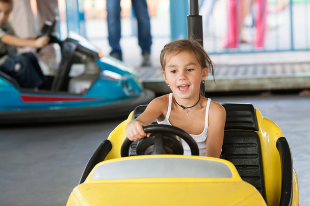 Happy lapsi ratsastaa sähköauto puistossa
 - Valokuva, kuva