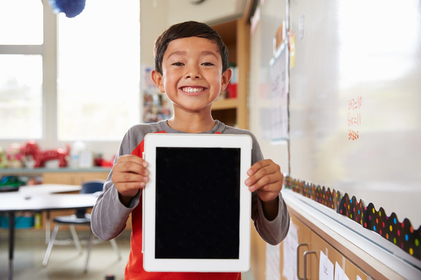 School boy holding up tablet computer - Zdjęcie, obraz