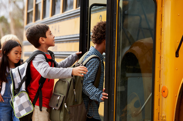 School kids climbing on to a school bus - Фото, изображение