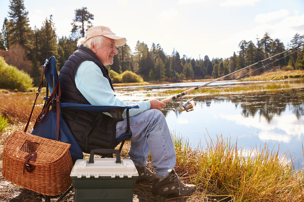Senior man fishing in a lake - Фото, зображення