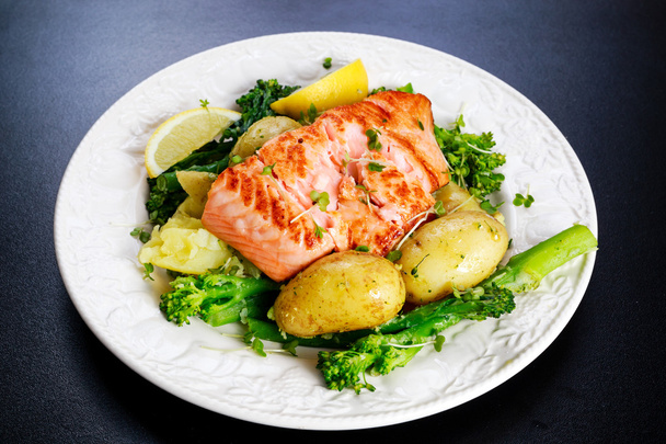 Pan fried Salmon Served with potatoes and tenderstem broccoli. - Photo, Image