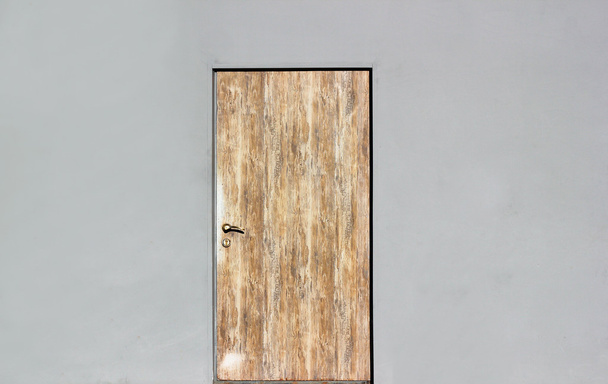 Background of a gray wall with closed wooden door. - Foto, Bild