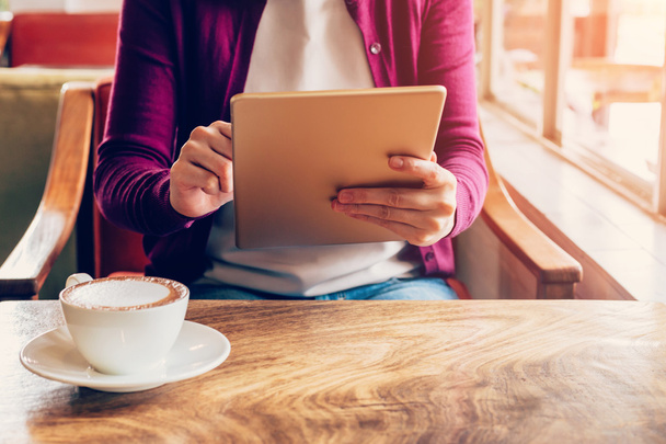 Kablosuz kullanarak ve bilgisayar tablet kahve tutan kadın el alışveriş - Fotoğraf, Görsel