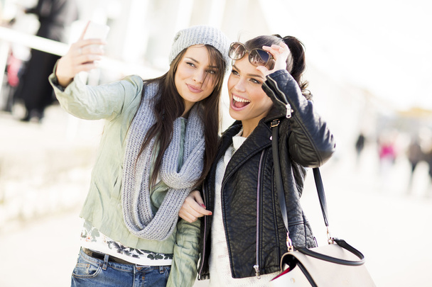 Молоді жінки приймають селфі на відкритому повітрі
 - Фото, зображення