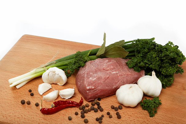 Carne cruda, verduras y especias aisladas sobre una mesa de madera
. - Foto, Imagen