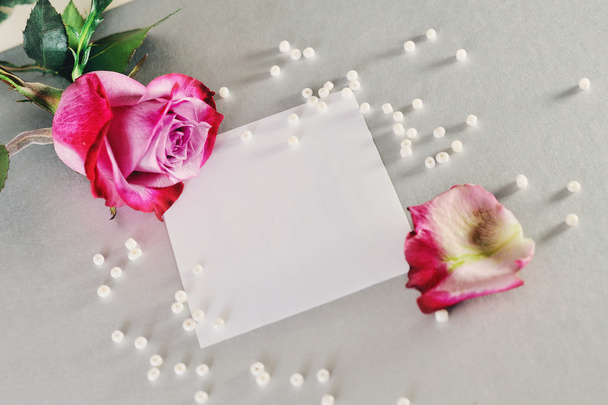 Pink rose and white pearls on a white sheet of paper - Фото, зображення