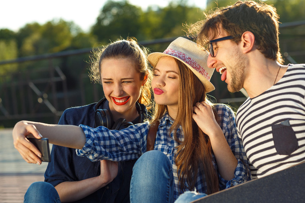 Glimlachend vrienden maken selfie buitenshuis - Foto, afbeelding
