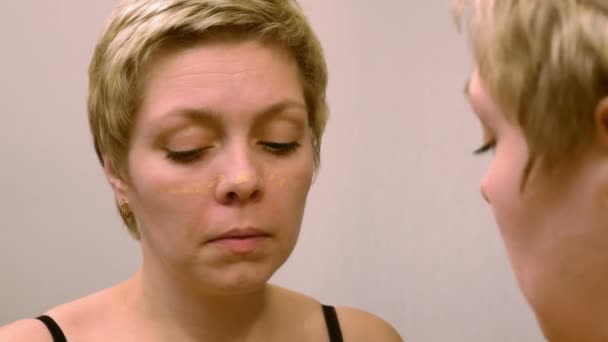 Nainen soveltaa meikki peitevoide meikkivoide
 - Materiaali, video