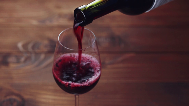 Red wine poured into glass  - Filmati, video