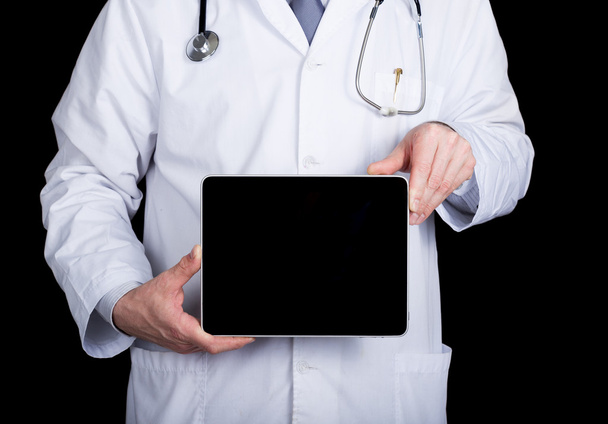 technology, internet and networking in medicine concept - Doctor holding a tablet pc with a blank dark screen. Internet technologies in medicine - Foto, afbeelding