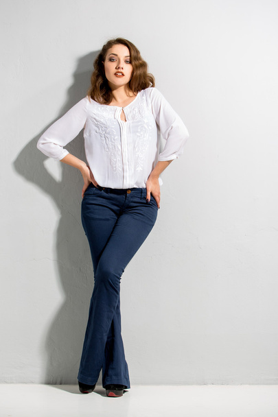 Beautiful woman with long legs in blouse and dark blue jeans - Fotoğraf, Görsel