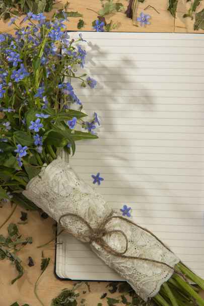 Spring bouquet of forget-me colors on the notebook on the wooden - Foto, Bild