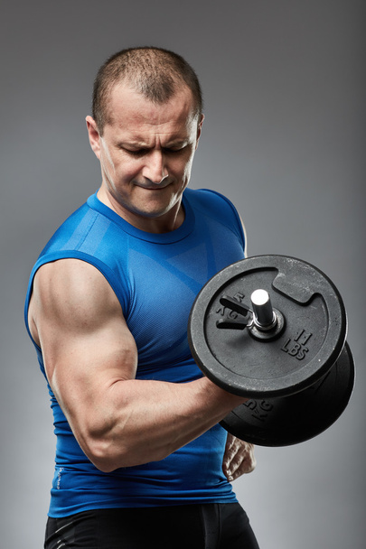 Man doing biceps curl with dumbbell  - Photo, image