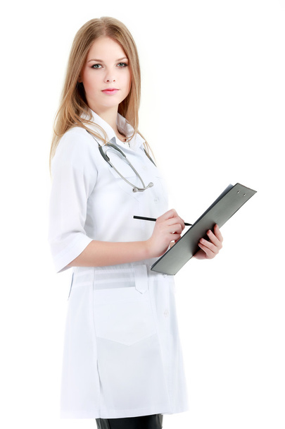 Retrato de una joven doctora con una bata blanca de pie en el hospital - Foto, Imagen