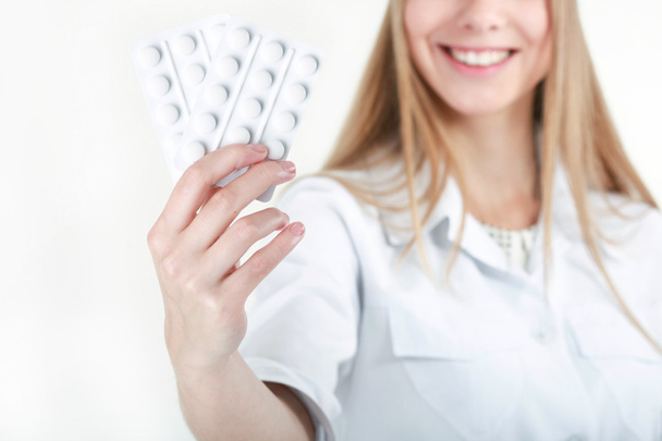 Una hermosa enfermera joven que ofrece pastillas
 - Foto, Imagen