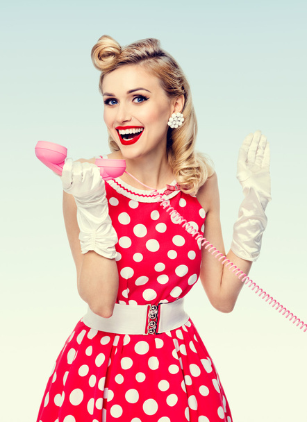 smiling woman with phone, dressed in pin-up style dress - Zdjęcie, obraz