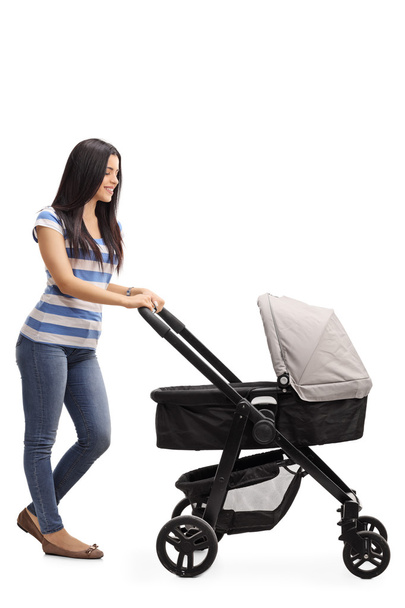 Young mother pushing a baby stroller  - Фото, зображення