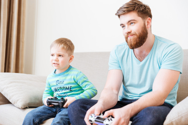 Sad unhappy dad and son playing computer games - 写真・画像