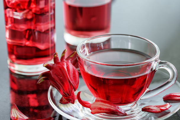 Cup of hibiscus tea (karkade, red sorrel) on table - Fotó, kép