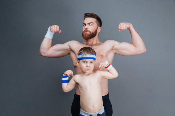 Strong bearded man and his son showing biceps - Foto, Imagem