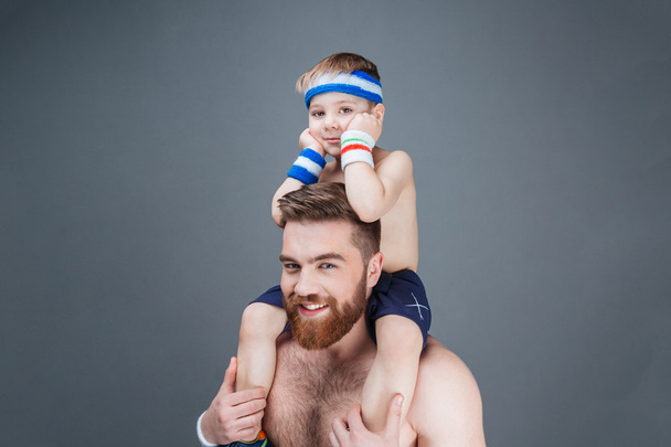 Happy bearded man with little son sitting on his shoulders - Foto, immagini