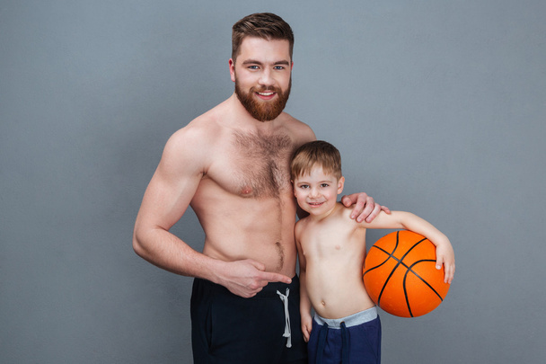 Happy shirtless dad and son holding basketball ball  - Photo, image