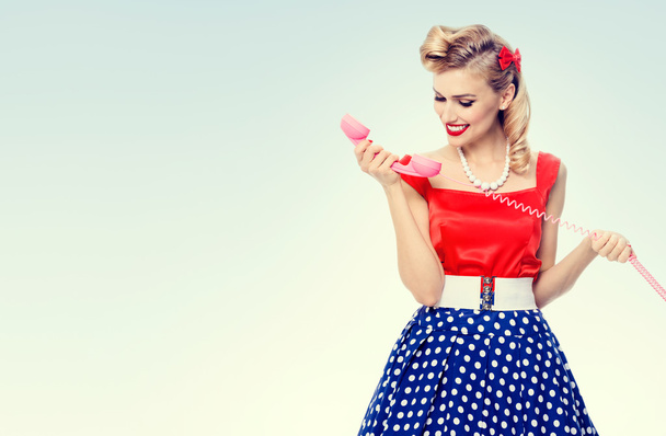 smiling woman with phone, dressed in pin-up style dress - Foto, Bild