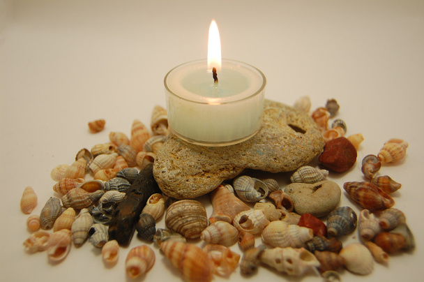 kamienie, dużo małych muszli i świeca - Zdjęcie, obraz