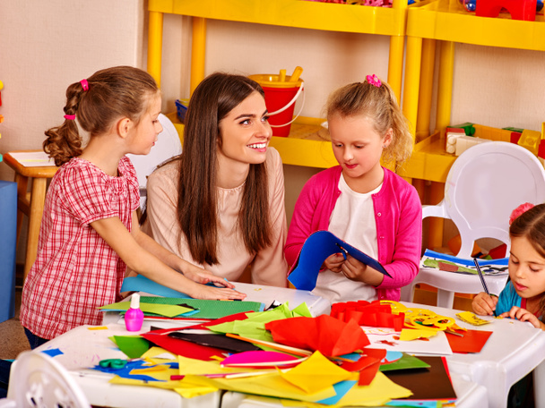 Gyerekek, akik színes papírt a asztali óvodában . - Fotó, kép