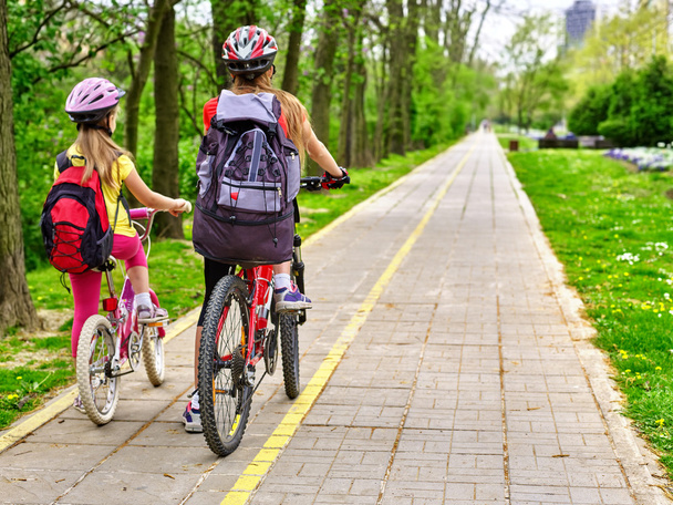 Ποδήλατα, ποδηλασία κορίτσια με σακίδιο ποδηλασία σε ποδήλατο λωρίδα. - Φωτογραφία, εικόνα