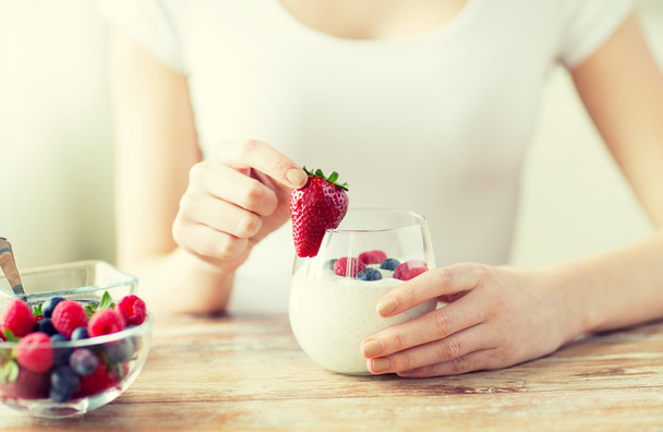 close up of woman hands with yogurt and berries - Foto, Imagen