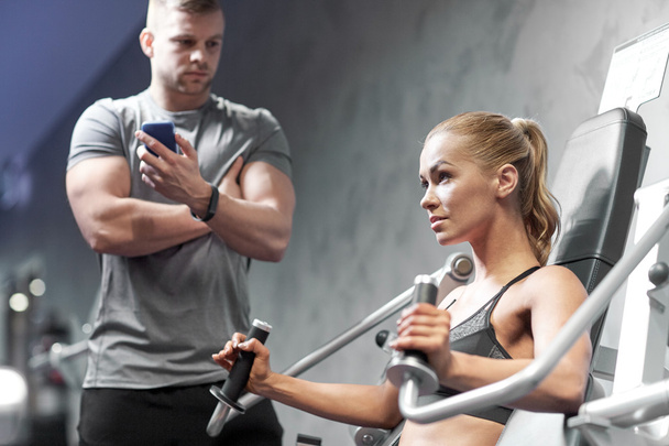 man and woman flexing muscles on gym machine - Фото, зображення