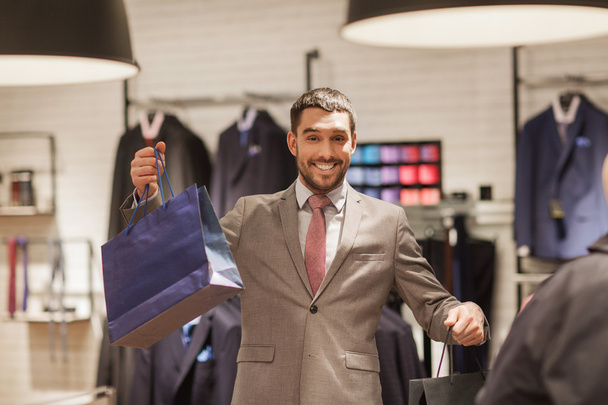 happy man with shopping bags at clothing store - Foto, Imagem