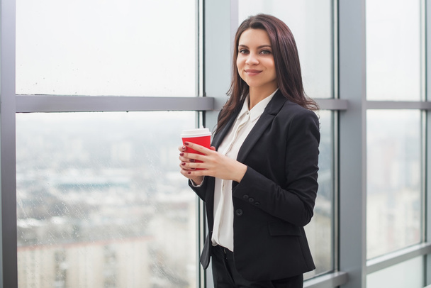 business woman standing at  window with cup - Foto, imagen